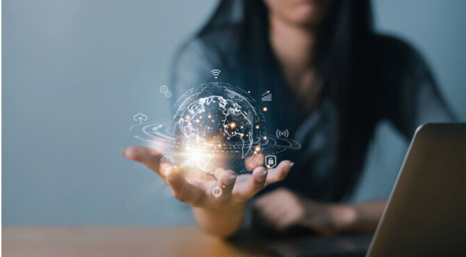 Woman holding virtual connectivity globe in palm of hand